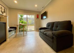 ein Wohnzimmer mit einem Sofa und einem Tisch in der Unterkunft Modern Private 2 Bedroom Home-unit in Albany with Netflix in Auckland