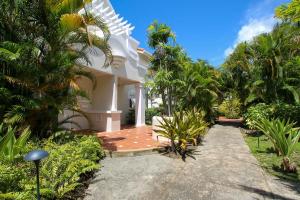 a white house with palm trees and a walkway at Turtle View 2 by BSL Rentals in Saint James