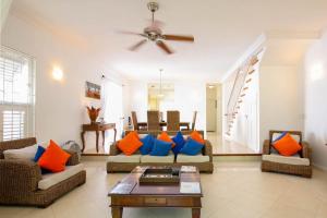 a living room with orange and blue pillows at Turtle View 2 by BSL Rentals in Saint James