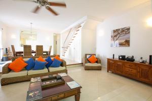 a living room with a couch with blue and orange pillows at Turtle View 2 by BSL Rentals in Saint James