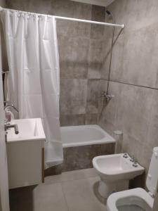 een badkamer met een bad, een toilet en een wastafel bij Depto Saladillo in Saladillo