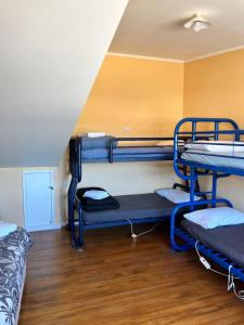 a room with three bunk beds and a wooden floor at Alpine Motel in Ohakune