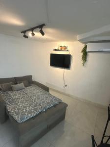 ein Schlafzimmer mit einem Bett und einem Flachbildfernseher in der Unterkunft Kitnet 6 pessoas na Barra in Salvador