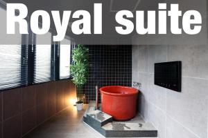 a red toilet in a bathroom with a sign that reads royal suite at 時のホテル in Toki