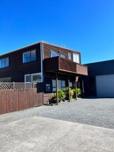 a black house with a fence and a garage at Alpine Motel in Ohakune