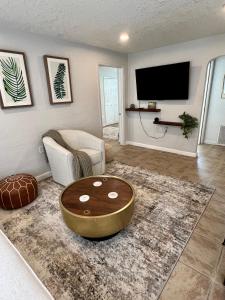 a living room with a table and a tv at Beautiful Bungalow in Orlando