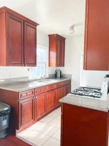 a kitchen with wooden cabinets and a stove top oven at Charming Century City Condo in Los Angeles