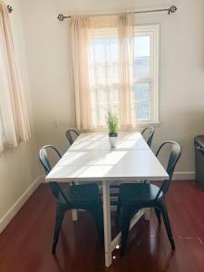 a white table with chairs and a potted plant on it at Charming Century City Condo in Los Angeles