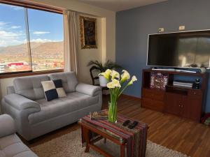 ein Wohnzimmer mit einem Sofa und einem TV in der Unterkunft hermoso departamento en zona residencial de cusco in Cusco