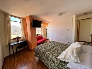 ein Hotelzimmer mit einem Bett, einem Schreibtisch und einem TV in der Unterkunft hermoso departamento en zona residencial de cusco in Cusco