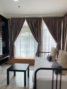 a living room with a bed and a table and a window at Parkview Suite KLCC, Myhomey in Kuala Lumpur