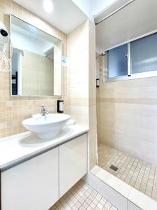 uma casa de banho com um lavatório e um chuveiro em City Star Lodge em Brisbane