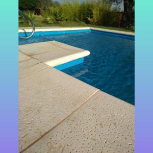 een zwembad met een betonnen platform in het water bij Cabañas Edna in Tinogasta
