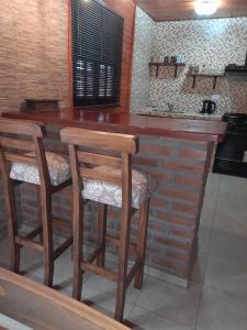 eine Küche mit einer Holzbar mit zwei Hockern in der Unterkunft Cabañas Edna in Tinogasta