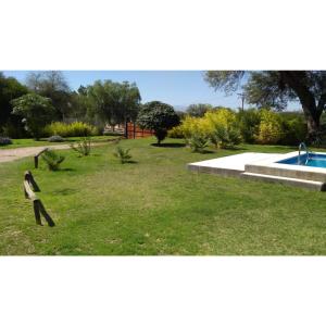 un parc avec un banc et une piscine dans l'établissement Cabañas Edna, à Tinogasta