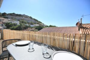 einen Tisch mit zwei Tellern und Gläsern auf dem Balkon in der Unterkunft Appart 1 ch clim - 50m des plages et des Calanques in Marseille