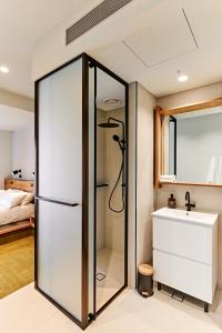 a bathroom with a shower and a sink at Central Club Hotel - North Melbourne in Melbourne