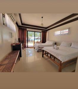 a large bedroom with two beds and a window at Bolo Hills Beach Club And Residence in Alaminos