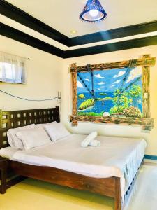 a bedroom with a bed with a painting on the wall at Bolo Hills Beach Club And Residence in Alaminos