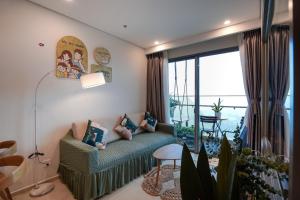 sala de estar con sofá y ventana grande en CONDOTEL THE SÓNG AN GIA VŨNG TÀU APARTMENT MrVƯƠNG en Vung Tau