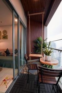 Habitación con balcón con mesa y columpio. en CONDOTEL THE SÓNG AN GIA VŨNG TÀU APARTMENT MrVƯƠNG en Vung Tau