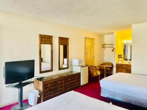 ein Hotelzimmer mit 2 Betten und einem Flachbild-TV in der Unterkunft San Miguel Inn in Socorro