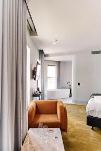 uma sala de estar com um sofá, uma cama e uma banheira em Central Club Hotel - North Melbourne em Melbourne
