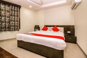 a bedroom with a large bed with red pillows at OYO Flagship Hotel Galaxy Palace in Ajmer