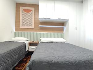 two beds sitting next to each other in a bedroom at Apartamento Sant'Ana in Porto Alegre