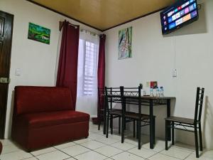 ein Wohnzimmer mit einem Stuhl, einem Tisch und einem TV in der Unterkunft Cabins Guayabon #2, AC, Arenal Volcano La Fortuna in Fortuna