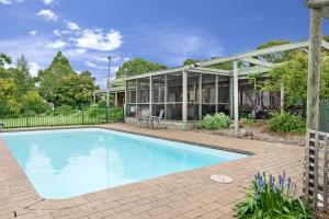 a swimming pool in front of a house at Gisborne Peak Winery Short Term Stays in Gisborne