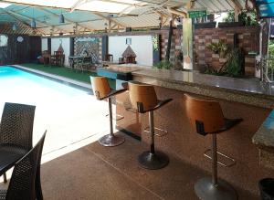 eine Bar mit Stühlen und einem Pool in der Unterkunft Udon Thai House Resort & Hotel in Udon Thani