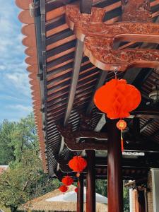 un grupo de sombrillas rojas colgando de un edificio en An Nam Hue Boutique en Cư Chinh