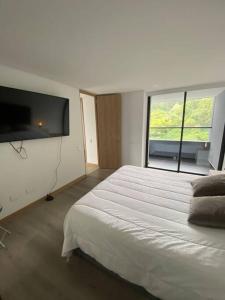 1 dormitorio con cama grande y ventana grande en TGBS AB 6 Pax, en Medellín