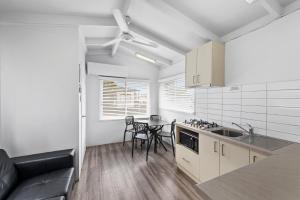 a kitchen with white cabinets and a table and chairs at BIG4 Ingenia Holidays Wagga Wagga in Wagga Wagga