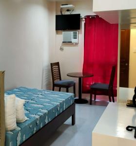 Zimmer mit einem Bett, einem Tisch und Stühlen in der Unterkunft Sea Horizon Resort in Zamboanguita