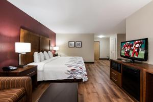 a hotel room with a bed and a flat screen tv at Red Roof Inn Newport News - Yorktown in Yorktown