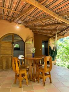 comedor con mesa de madera y sillas en Casa Magica, en Minca