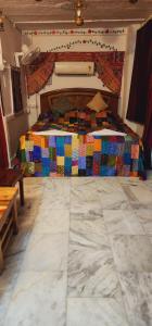 a bedroom with a bed with a colorful quilt at Jodhpur Heritage Haveli Guest House in Jodhpur