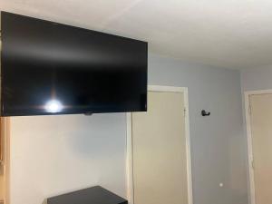 uma televisão de ecrã plano pendurada no tecto de um quarto em Spacious & Cozy Studio, Short Walk to Yale em New Haven