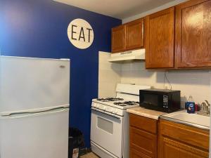 uma cozinha com um fogão branco e um frigorífico em Spacious & Cozy Studio, Short Walk to Yale em New Haven