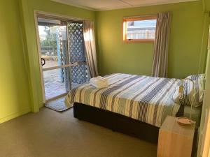 Omaha的住宿－Shamrock Getaway，一间卧室设有一张床和一个滑动玻璃门