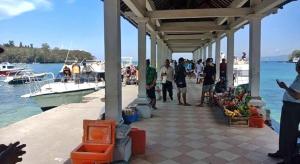 eine Gruppe von Menschen, die auf einem Dock mit Booten stehen in der Unterkunft Gilibooking ticket in Padangbai