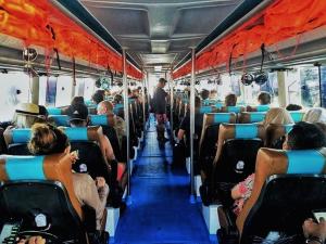 Un autobús lleno de gente sentada en un autobús en Gilibooking ticket en Padangbai