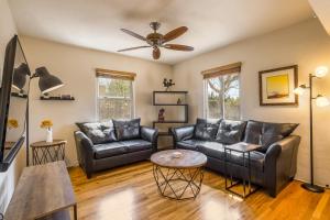 a living room with leather furniture and a ceiling fan at Nob Hill Home with Private Yard! in Albuquerque