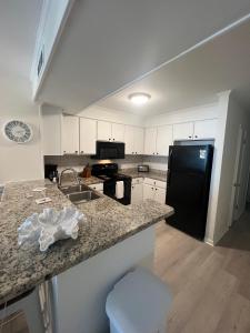 a kitchen with a sink and a black refrigerator at Diamond on the Shore in Myrtle Beach