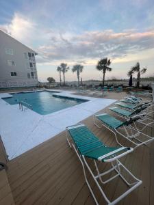 a group of lounge chairs sitting next to a swimming pool at Diamond on the Shore in Myrtle Beach