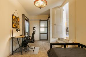 a bedroom with a desk and a bed and a chair at Nob Hill Home with Private Yard! in Albuquerque