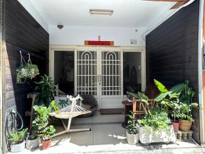 un porche con plantas y un cartel en la puerta en Back to spring BnB, en Hengchun