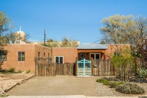 a brick house with a fence and a gate at Nob Hill Home with Private Yard! in Albuquerque